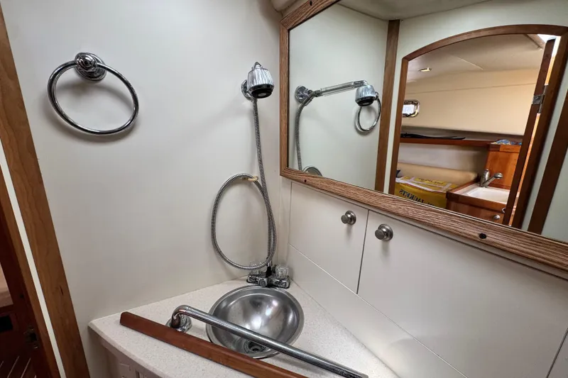 Slide: The Image of 2004 Mainship Pilot 30 Rum Runner bathroom with sink, mirror, and shower fixtures. - 52