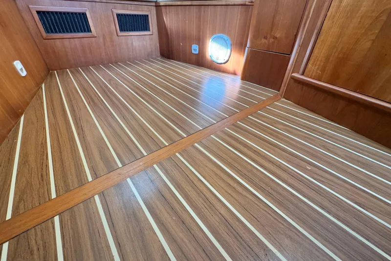 Slide: The Image of 2004 Mainship Pilot 30 Rum Runner interior with wood paneling and striped flooring. - 53