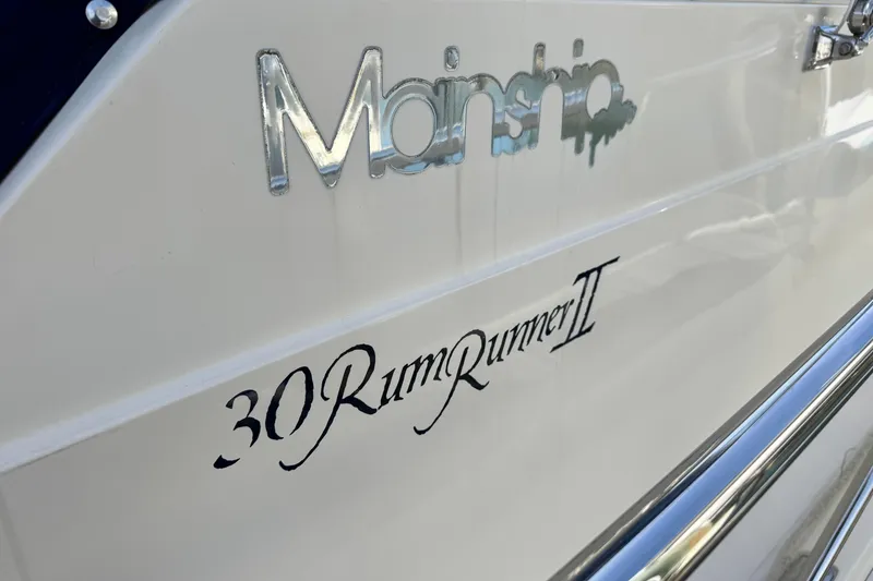 Slide: The Image of 2004 Mainship Pilot 30 Rum Runner II boat nameplate with chrome lettering. - 55