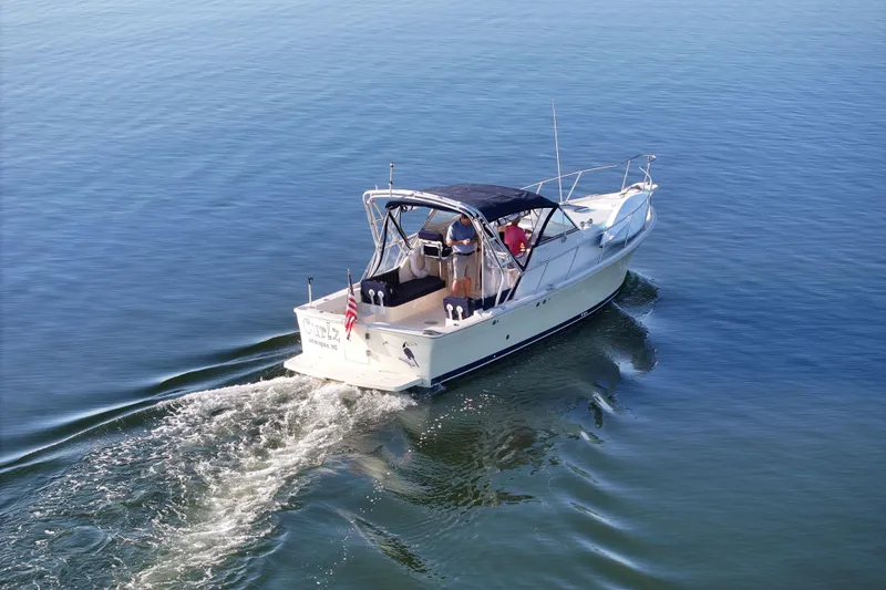 Slide: The Image of 2004 Mainship Pilot 30 Rum Runner cruising on calm blue waters. - 6