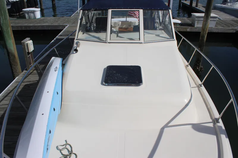 Slide: The Image of 2004 Mainship Pilot 30 Rum Runner boat docked at marina, front deck view. - 60