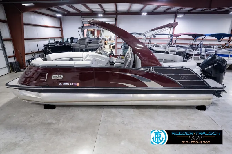 The Image of 2022 Bennington 23 QXFBA pontoon boat in showroom, featuring sleek design and Mercury engine. - 0