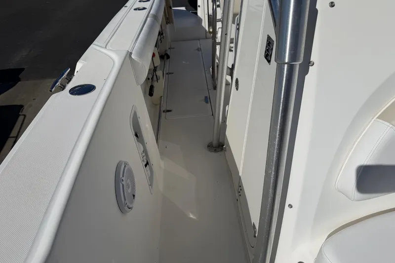 Slide: The Image of 2004 Boston Whaler 270 Outrage boat interior, featuring sleek white deck and stainless steel railings. - 10