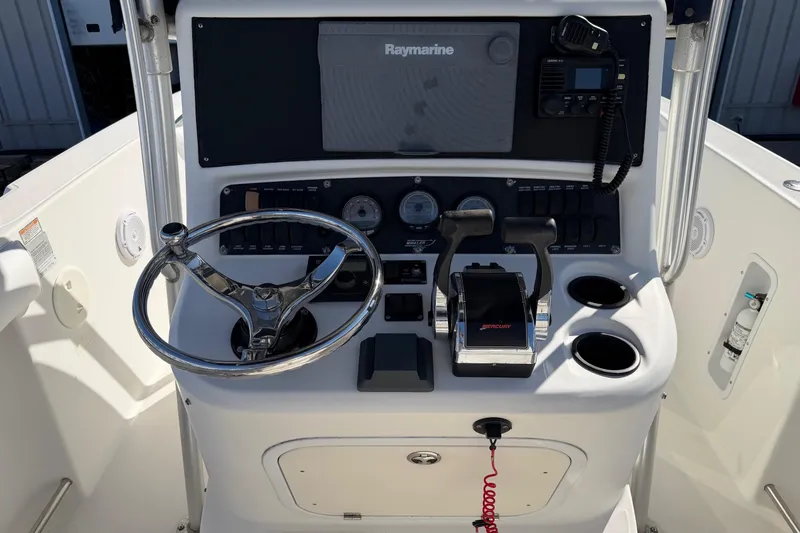 Slide: The Image of Boston Whaler 270 Outrage 2004 helm with steering wheel, controls, and Raymarine electronics. - 16