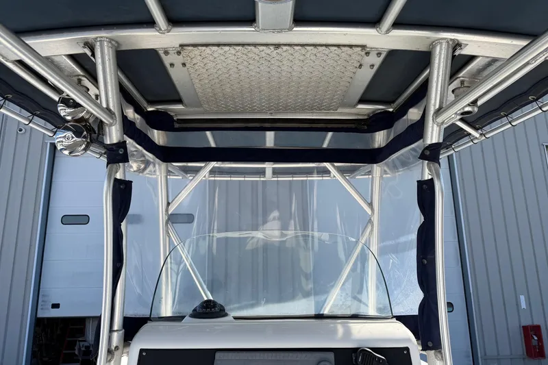 Slide: The Image of 2004 Boston Whaler 270 Outrage boat with T-top and windshield, docked in a marina. - 17