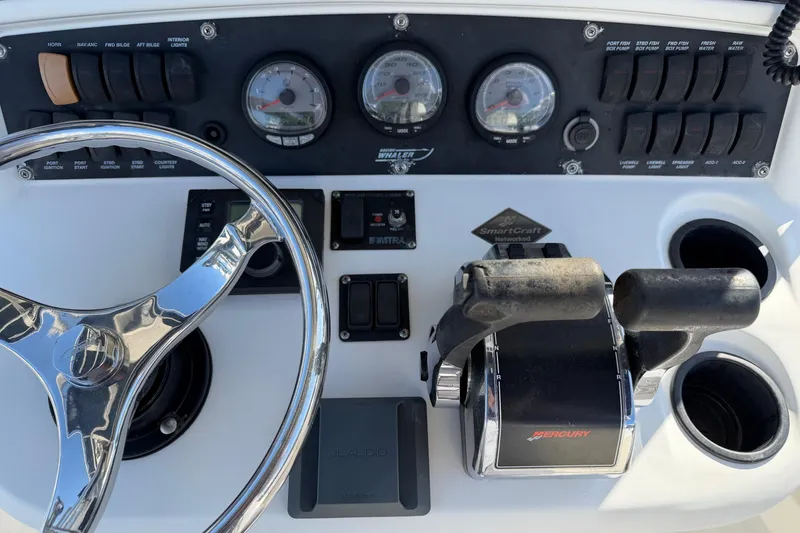 Slide: The Image of Control panel of a 2004 Boston Whaler 270 Outrage boat with steering wheel and throttle. - 24