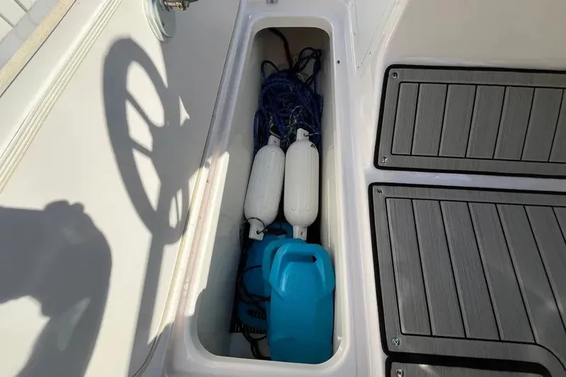 Slide: The Image of Storage compartment on 2024 Yamaha Boats 195S, containing ropes and fenders. - 11