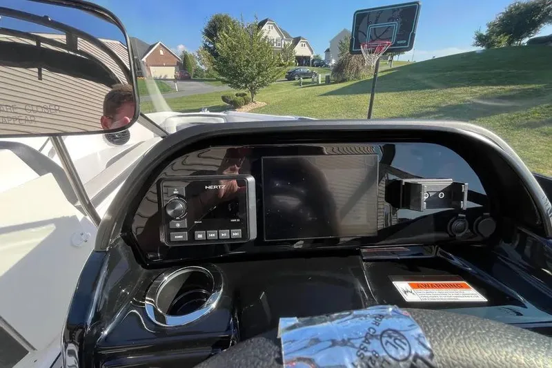 Slide: The Image of 2024 Yamaha Boats 195S dashboard with navigation screen and controls, parked in a residential area. - 9