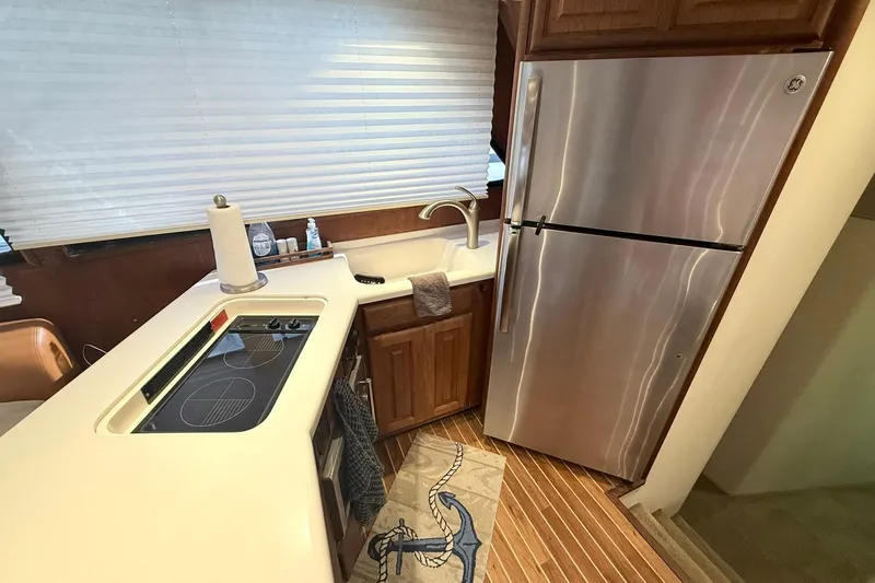 Slide: The Image of 1992 Viking 50 Convertible yacht kitchen with stainless steel fridge and electric stove. - 19
