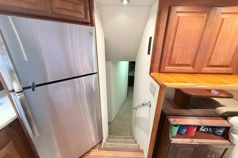 Slide: The Image of Interior of 1992 Viking 50 Convertible yacht with stainless steel fridge and wooden cabinetry. - 20