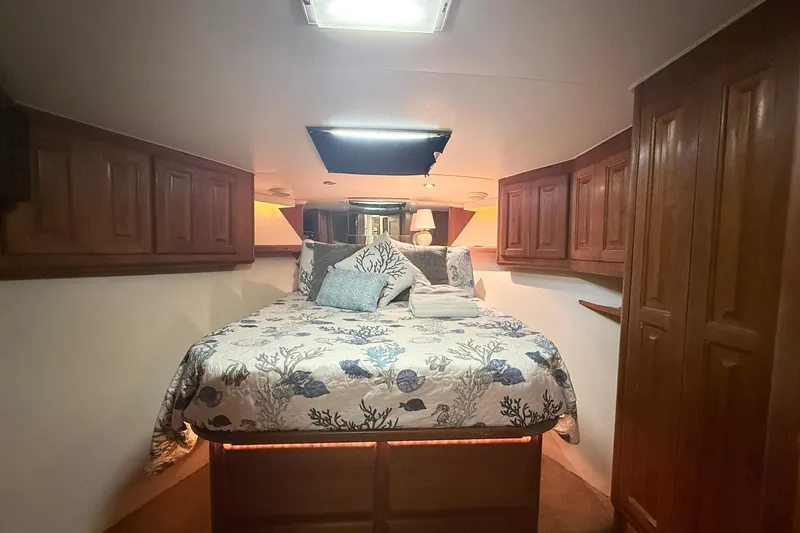 Slide: The Image of Cozy bedroom in 1992 Viking 50 Convertible yacht with floral bedding and wooden cabinets. - 22