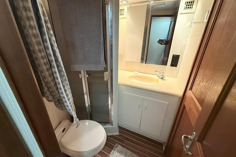 Slide: The Image of Bathroom interior of 1992 Viking 50 Convertible yacht, featuring sink, mirror, and shower. - 23