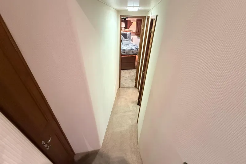 Slide: The Image of Narrow hallway inside 1992 Viking 50 Convertible yacht, leading to a cozy bedroom. - 25