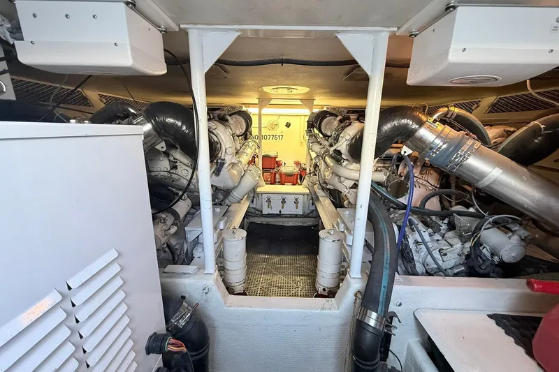 Slide: The Image of Engine room of a 1992 Viking 50 Convertible yacht, showcasing dual engines and mechanical components. - 28