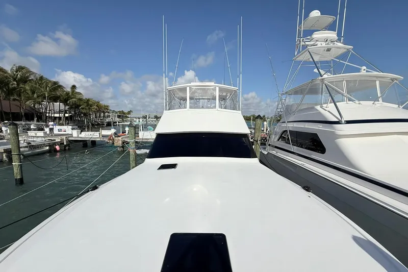 Slide: The Image of 1992 Viking 50 Convertible yacht docked at marina under clear blue sky. - 35