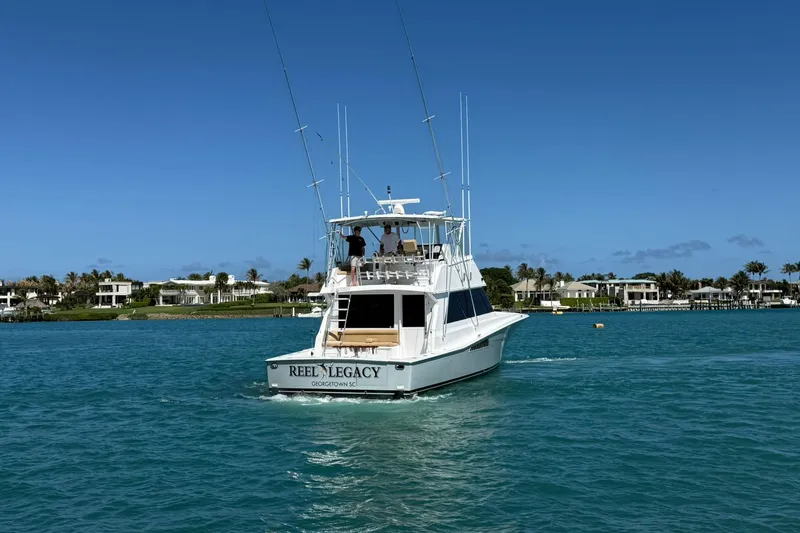 Slide: The Image of 1992 Viking 50 Convertible yacht cruising on clear blue waters near luxury waterfront homes. - 37