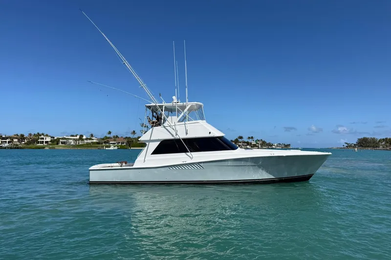 Slide: The Image of 1992 Viking 50 Convertible yacht on calm blue water under clear sky. - 38