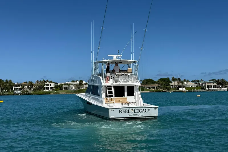 Slide: The Image of 1992 Viking 50 Convertible yacht "Reel Legacy" cruising in clear blue waters. - 39