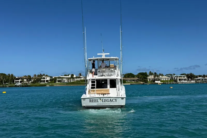 Slide: The Image of 1992 Viking 50 Convertible yacht "Reel Legacy" cruising in clear blue waters. - 41