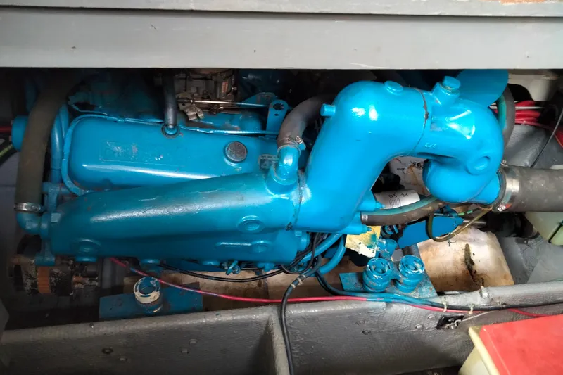 Slide: The Image of Engine compartment of a 1990 Mainship 41 Grand Salon, featuring a blue marine engine. - 11