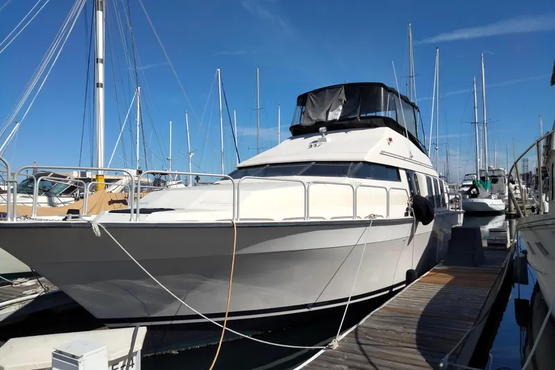 Slide: The Image of 1990 Mainship 41 Grand Salon yacht docked at marina under clear blue sky. - 14