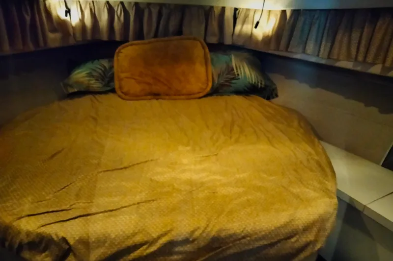 Slide: The Image of Cozy bedroom interior of 1990 Mainship 41 Grand Salon yacht with warm lighting. - 6