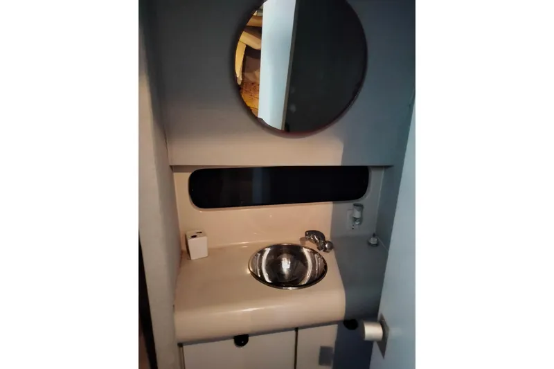 Slide: The Image of Bathroom vanity with round mirror in 1990 Mainship 41 Grand Salon yacht. - 8