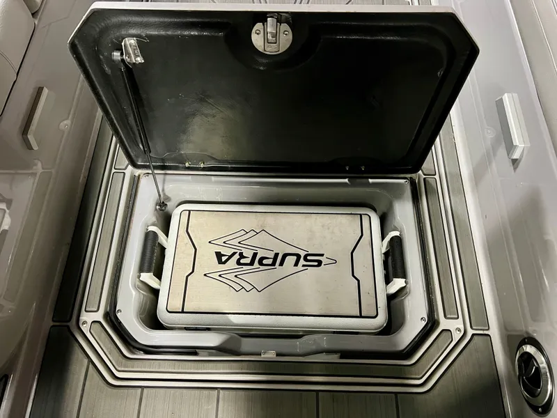Slide: The Image of 2021 Supra SE 450 storage compartment with logo detail. - 17