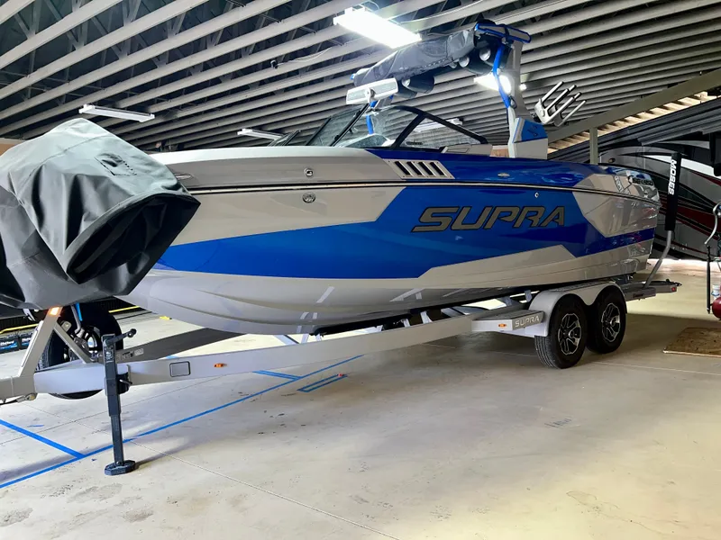 Slide: The Image of 2021 Supra SE 450 boat in a garage on a trailer. - 2