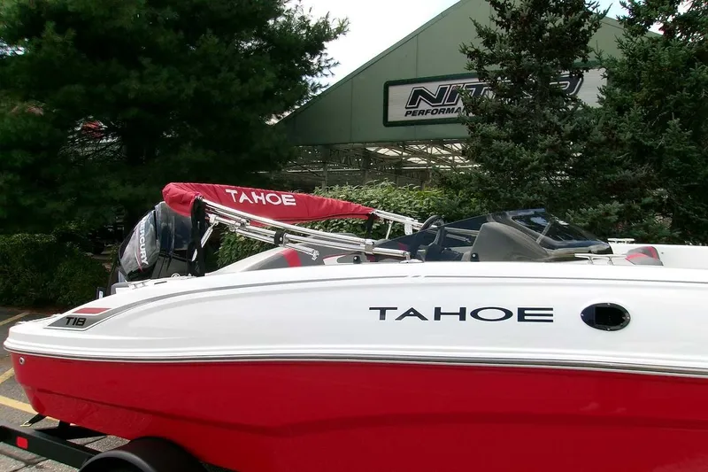 Slide: The Image of 2026 Tahoe T18 boat with red and white design, parked near Nitro Performance building. - 1
