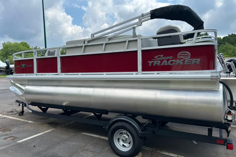 The Image of 2026 Sun Tracker Bass Buggy 18 DLX pontoon boat on trailer, parked outdoors. - 0