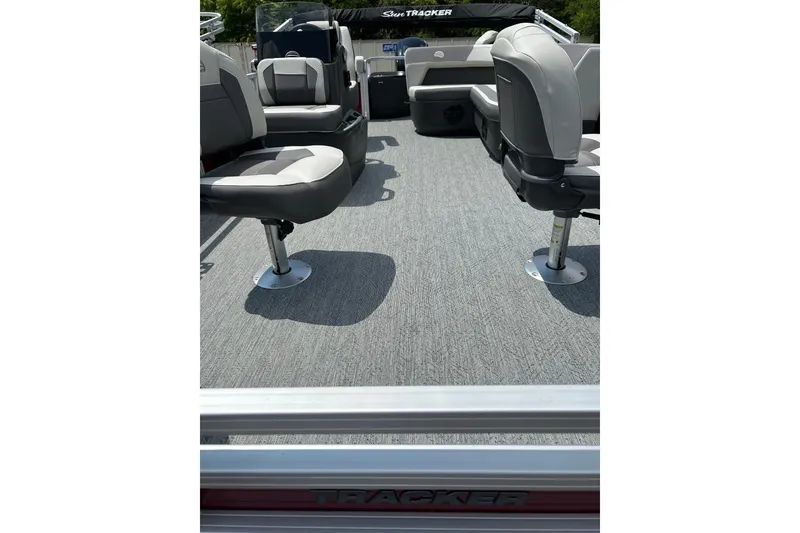 Slide: The Image of 2026 Sun Tracker Bass Buggy 18 DLX interior with gray seating and carpeted flooring. - 2