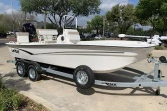 Slide: The Image of 2026 Mako Pro Skiff 19 CC boat on trailer, parked outdoors. - 2