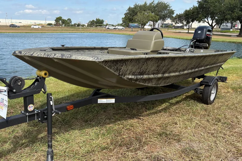 The Image of 2026 Tracker Grizzly 1648 SC boat on trailer by a lake. - 0