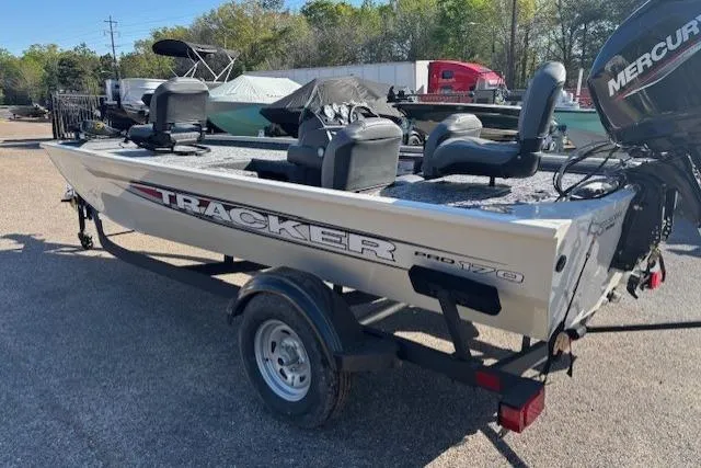 Slide: The Image of 2026 Tracker Pro 170 boat on trailer with Mercury outboard motor, parked outdoors. - 2