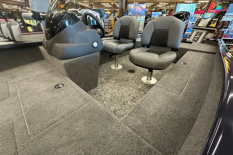 Slide: The Image of 2026 Tracker Super Guide V-16 SC boat interior with two gray seats and carpeted flooring. - 25
