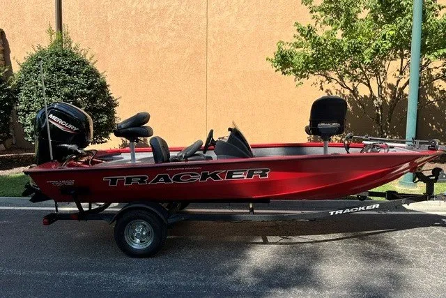 The Image of 2026 Tracker Pro Team 175 Crappie Edition boat, red, on trailer, parked outdoors. - 0
