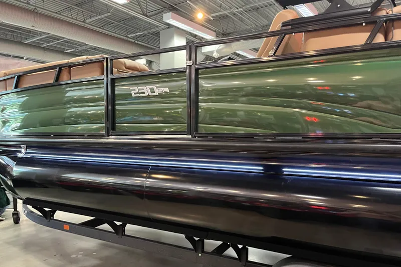Slide: The Image of 2026 Regency 230 DL pontoon boat in showroom, green and black exterior. - 4