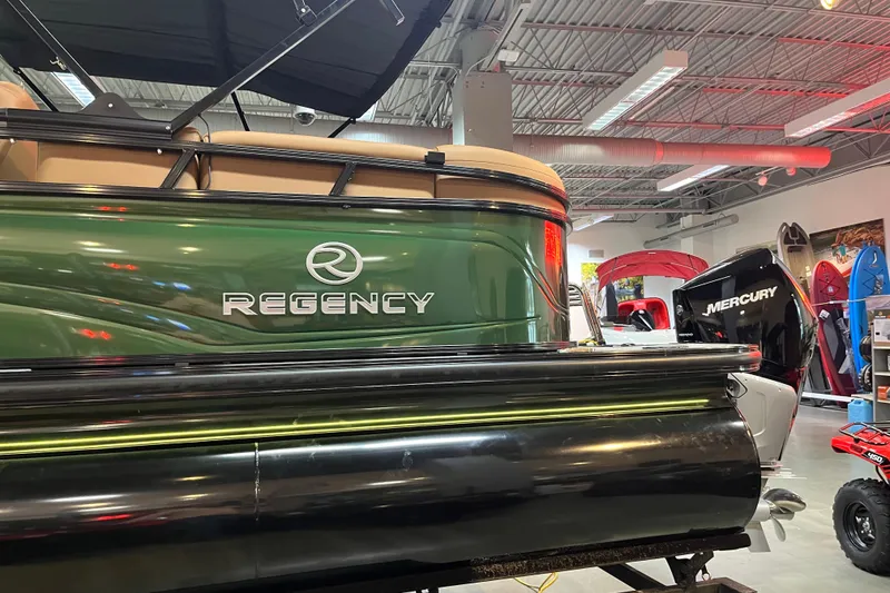 Slide: The Image of 2026 Regency 230 DL pontoon boat displayed indoors with Mercury engine. - 5