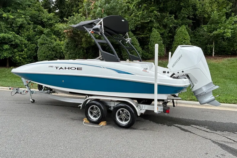 Slide: The Image of 2026 Tahoe 2150 boat on trailer with Mercury outboard, parked on a road. - 5