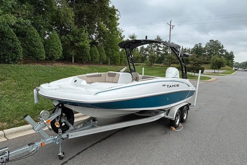 Slide: The Image of 2026 Tahoe 2150 boat on trailer, parked on a road with lush greenery. - 3