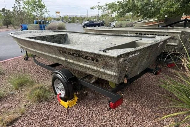 Slide: The Image of 2026 Tracker Grizzly 1648 Utility boat on trailer, parked outdoors on gravel. - 2