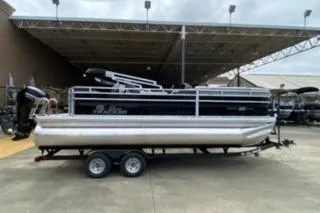 The Image of 2026 Sun Tracker SportFish 20 DLX pontoon boat on trailer, parked outdoors. - 0