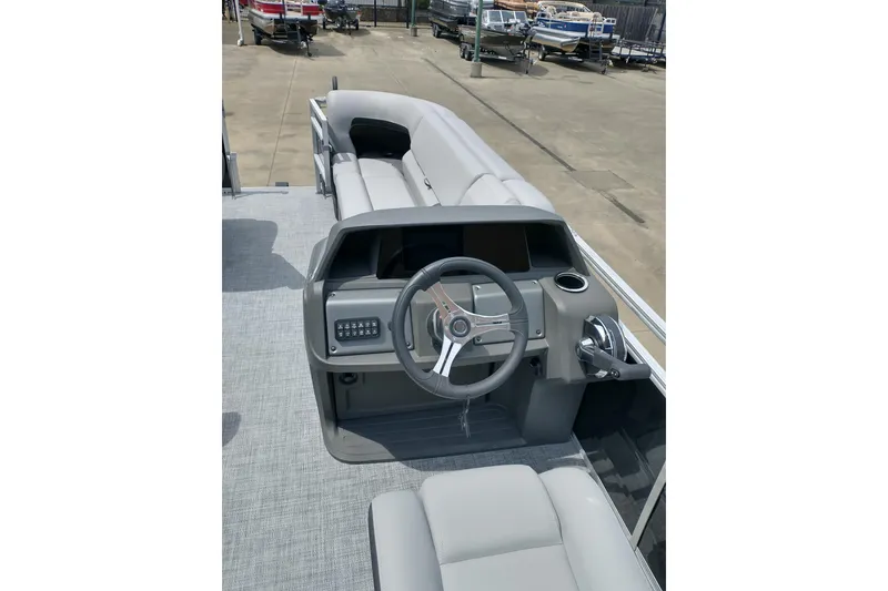 Slide: The Image of 2026 Sun Tracker SportFish 20 DLX pontoon boat interior with steering console and seating. - 18