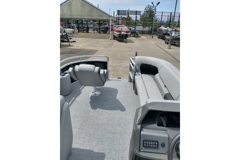 Slide: The Image of 2026 Sun Tracker SportFish 20 DLX pontoon boat interior with seating and control panel. - 19