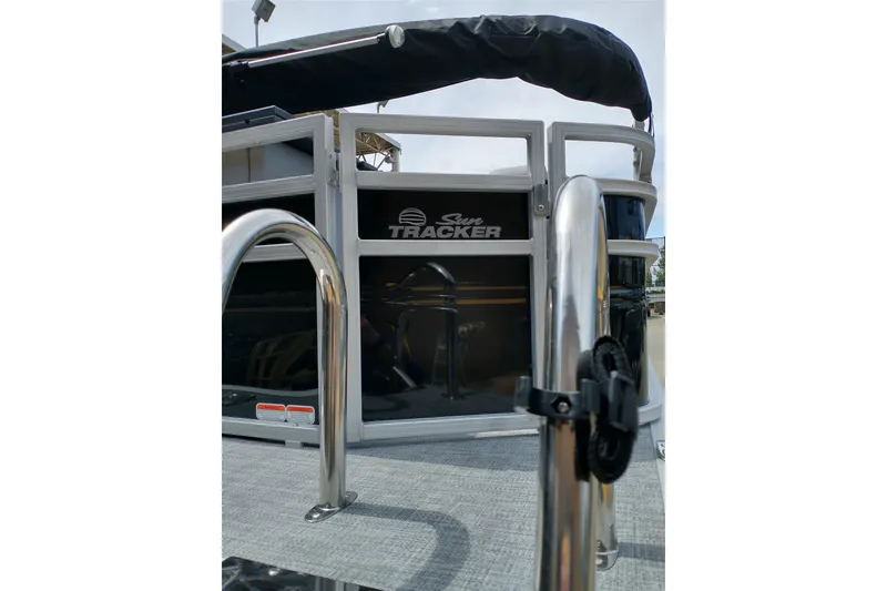 Slide: The Image of 2026 Sun Tracker SportFish 20 DLX pontoon boat, rear view with railing and logo. - 7