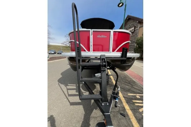 Slide: The Image of 2026 Sun Tracker Party Barge 20 DLX on trailer, red exterior, parked outdoors. - 79