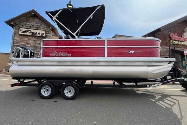 Slide: The Image of 2026 Sun Tracker Party Barge 20 DLX pontoon boat on trailer, parked outdoors. - 80