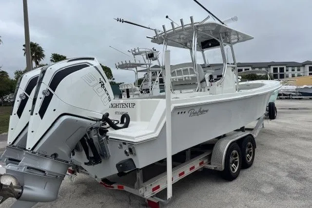 Slide: The Image of 2024 Pair Customs 27 Center Console boat on trailer, featuring dual engines. - 2