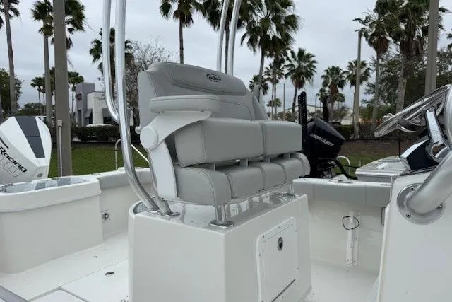 Slide: The Image of 2024 Pair Customs 27 Center Console boat with sleek seating, palm trees in background. - 7